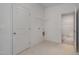 Well-lit laundry room with tile flooring, washer hookups, and storage racks, ideal for home organization at 402 Suhani Ln, Clayton, NC 27520