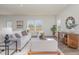 Bright living room featuring neutral furniture, wood floors, and large windows overlooking the backyard at 402 Suhani Ln, Clayton, NC 27520