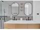 Modern bathroom featuring double sinks, wood cabinets, and stylish mirrors and light fixtures at 409 Alston St # 101, Raleigh, NC 27601