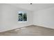 Bright bedroom featuring herringbone floors and a large window with a view of the house next door at 409 Alston St # 101, Raleigh, NC 27601