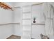 Organized walk-in closet with built-in shelving, hanging rods, and herringbone floors at 409 Alston St # 101, Raleigh, NC 27601