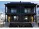 Modern black townhouse with two stories, balconies, black railings, and bright yellow doors at 409 Alston St # 101, Raleigh, NC 27601