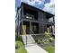 Modern two-story home featuring a striking dark exterior and a vibrant yellow front door at 409 Alston St # 101, Raleigh, NC 27601