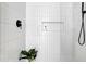 Modern shower with white tile, a niche for toiletries, and black fixtures at 409 Alston St # 101, Raleigh, NC 27601