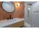 Modern bathroom features a round mirror, stylish vanity, and a walk-in shower with glass door and vertical tiles at 409 Alston St # 102, Raleigh, NC 27601