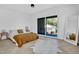 Sunlit bedroom with herringbone floors, access to a balcony, and minimalist decor at 409 Alston St # 102, Raleigh, NC 27601