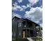 Contemporary black home featuring a yellow front door, complemented by a blue sky with puffy white clouds at 409 Alston St # 102, Raleigh, NC 27601