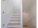 Bright staircase featuring herringbone floors, white risers, and white handrail at 409 Alston St # 102, Raleigh, NC 27601