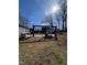 A sunny backyard with mature trees, a patio with a pergola, and ample space for outdoor activities at 472 Cedar Ln, Mebane, NC 27302