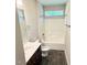 This bathroom showcases a shower/tub, a dark wooden vanity, and a decorative faux-wood floor at 495 Cheves Rd # 495, Zebulon, NC 27597