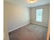 This carpeted bedroom features a neutral palette and natural light from a window with white blinds at 495 Cheves Rd # 495, Zebulon, NC 27597