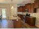 Kitchen with dark wood cabinets, granite countertops, stainless steel appliances, and a center island at 495 Cheves Rd # 495, Zebulon, NC 27597