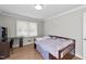 Bright bedroom offers a wooden bed frame, hardwood floors, and a study area near the window at 539 N Oneil St, Clayton, NC 27520