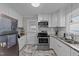 Modern kitchen featuring stainless steel appliances, granite countertops, and white cabinetry at 539 N Oneil St, Clayton, NC 27520