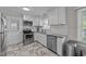 Well-lit kitchen featuring white cabinets, stainless steel appliances, granite countertops and patterned tile flooring at 539 N Oneil St, Clayton, NC 27520