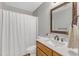 Clean bathroom with a shower and white vanity, plus a dark wood framed mirror at 5508 Lake Garden Ct, Raleigh, NC 27610