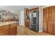 Kitchen area featuring stainless steel refrigerator, wooden cabinets, granite countertops, and access to living area at 5508 Lake Garden Ct, Raleigh, NC 27610