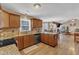 Bright, airy kitchen with wooden cabinets, granite countertops, and an open view to the dining and living spaces at 5508 Lake Garden Ct, Raleigh, NC 27610