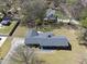 Aerial view of a residential property with a large yard, mature trees, and a paved driveway at 5705 Dean Ave, Raleigh, NC 27616