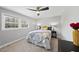 Cozy bedroom with neutral walls, carpet flooring, a large window, and stylish decor at 5705 Dean Ave, Raleigh, NC 27616