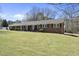 Expansive single-story brick home with a well-maintained lawn, showcasing its generous lot size at 5705 Dean Ave, Raleigh, NC 27616
