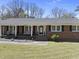 Charming brick home with a welcoming front porch and landscaped yard, perfect for enjoying the outdoors at 5705 Dean Ave, Raleigh, NC 27616