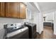 This laundry room includes modern washer and dryer units, overhead cabinets and shelving at 5705 Dean Ave, Raleigh, NC 27616