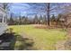 Spacious backyard with a large lawn, mature trees, and garden area at 5811 Shawood Dr, Raleigh, NC 27609