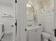 Elegant powder room featuring monkey wallpaper, white wainscoting, and brass fixtures at 5811 Shawood Dr, Raleigh, NC 27609