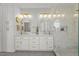 Bright bathroom featuring double vanity, white cabinetry, gold hardware, and a seamless glass shower at 5811 Shawood Dr, Raleigh, NC 27609
