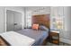 Cozy bedroom showcasing a wooden bed frame, stylish decor, and inviting natural light from two windows at 5811 Shawood Dr, Raleigh, NC 27609