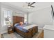 Comfortable bedroom with a wooden bed frame, neutral colors, and ample natural light from two windows at 5811 Shawood Dr, Raleigh, NC 27609