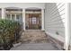Elegant home exterior with a stone facade, wood door, and manicured landscaping at 5811 Shawood Dr, Raleigh, NC 27609
