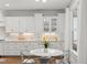 Bright kitchen featuring white cabinets, herringbone backsplash, and a round table with modern chairs at 5811 Shawood Dr, Raleigh, NC 27609
