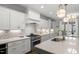 Modern kitchen with white cabinetry, stainless steel appliances, and quartz countertops at 5811 Shawood Dr, Raleigh, NC 27609
