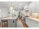 Spacious kitchen with white cabinets, stainless steel appliances, hardwood floors, and a marble-topped island at 5811 Shawood Dr, Raleigh, NC 27609