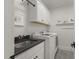 Bright laundry room features modern machines, a sleek black sink, and ample cabinet space with neutral colors at 5811 Shawood Dr, Raleigh, NC 27609
