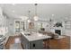 Open concept kitchen and living area with hardwood floors, a fireplace, and a kitchen island with bar stools at 5811 Shawood Dr, Raleigh, NC 27609