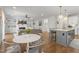 Open-concept living space featuring built-in shelving, a fireplace, and a kitchen island with seating at 5811 Shawood Dr, Raleigh, NC 27609