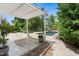 Large backyard stone patio with pergola and backyard pool surrounded by lush landscaping at 5811 Shawood Dr, Raleigh, NC 27609