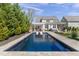 Backyard view of the pool and home with a white pergola covered patio at 5811 Shawood Dr, Raleigh, NC 27609