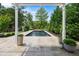 Backyard pool surrounded by a beautiful stone patio and lush landscaping viewed from a pergola at 5811 Shawood Dr, Raleigh, NC 27609