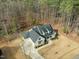 Stunning aerial view of a modern farmhouse with a sleek, dark roof and well-maintained landscaping at 76 Gentry Dr, Pittsboro, NC 27312