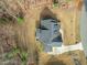 A high-angle view of a residence featuring a well-designed roof, backyard deck, and surrounding lush landscape at 76 Gentry Dr, Pittsboro, NC 27312