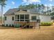 View of the back exterior of the house, showcasing a screened-in porch, deck, and well-manicured lawn at 76 Gentry Dr, Pittsboro, NC 27312