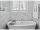 Close up of soaking tub with marble surround, shutters, and chrome fixtures at 76 Gentry Dr, Pittsboro, NC 27312