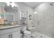 Modern bathroom featuring marble tile, glass shower, granite countertops, and white cabinetry at 76 Gentry Dr, Pittsboro, NC 27312