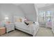 Cozy bedroom features a bed with many pillows, end tables, and a reading chair at 76 Gentry Dr, Pittsboro, NC 27312