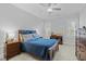Spacious bedroom with a blue quilt, ceiling fan, and dark wood furniture at 76 Gentry Dr, Pittsboro, NC 27312