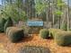 Stone community entrance sign for Pennington at Jordan Lake surrounded by lush landscaping and mature trees at 76 Gentry Dr, Pittsboro, NC 27312